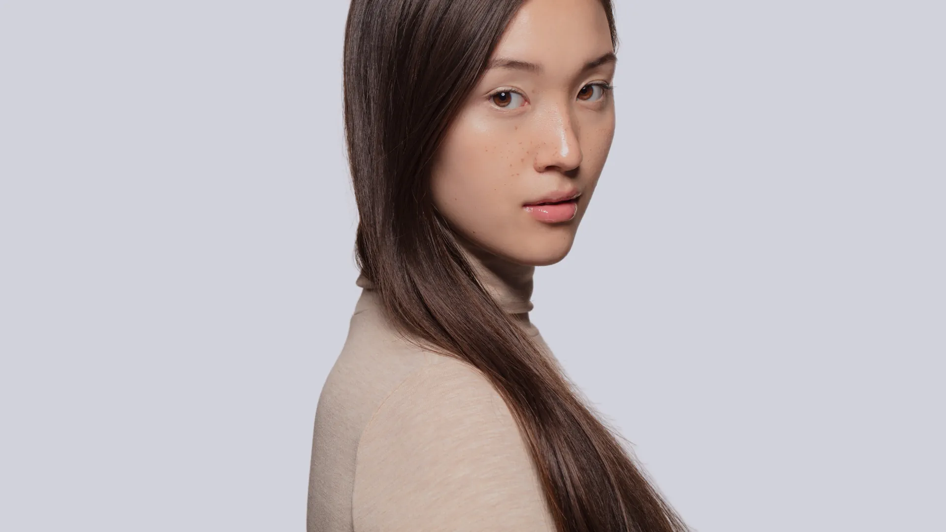 Beautiful asian with long brown hair in brownish top.